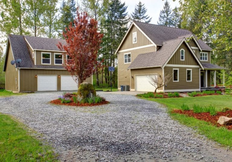 Countryside house exterior with garage. View of entrance and gravel driveway in cetral texas